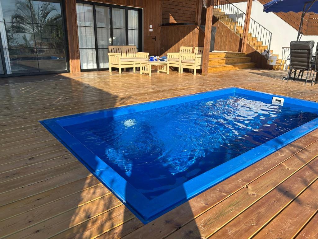 提比里亚מבית תכלת בית של חופש Allentown 21 אלנטאון 21的木制甲板上的蓝色玻璃纤维游泳池