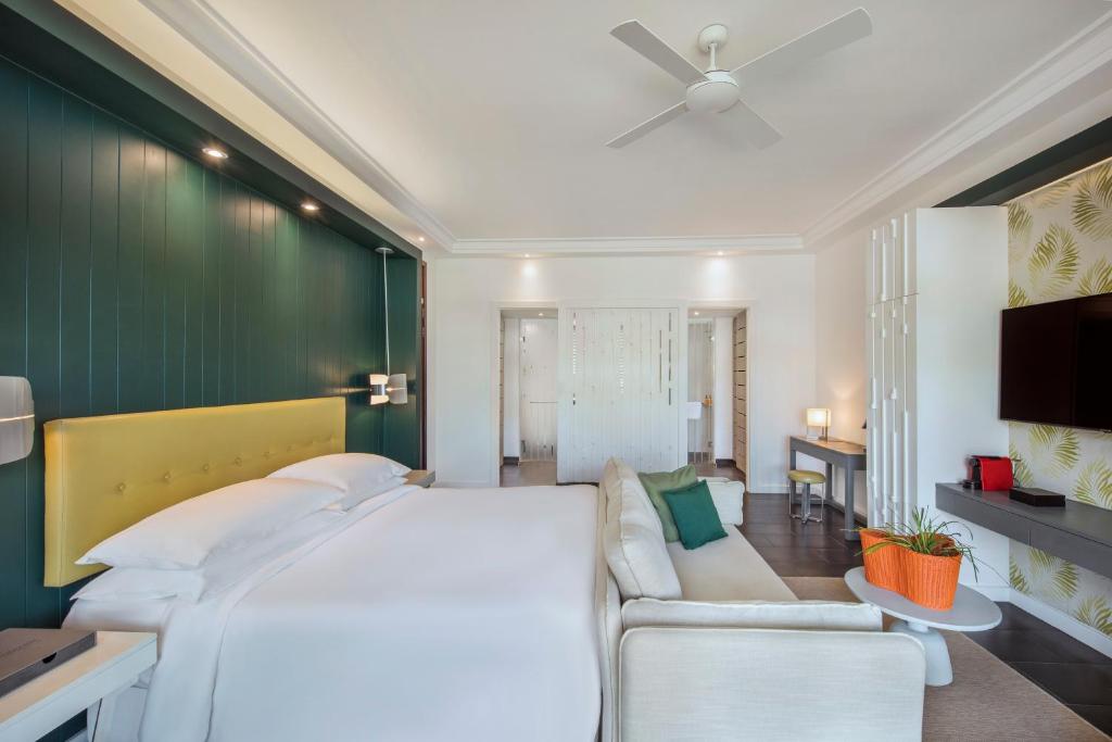 贝尔马尔Long Beach Mauritius的一间卧室配有一张大床和一张沙发