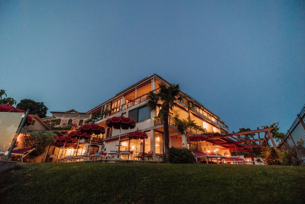 波尔托罗Villa Bellevue Portoroz-Portorose的前面有红伞的大建筑