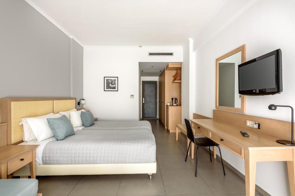 帕琉乔拉利比亚公主酒店的酒店客房配有一张床、一张书桌和一台电视。