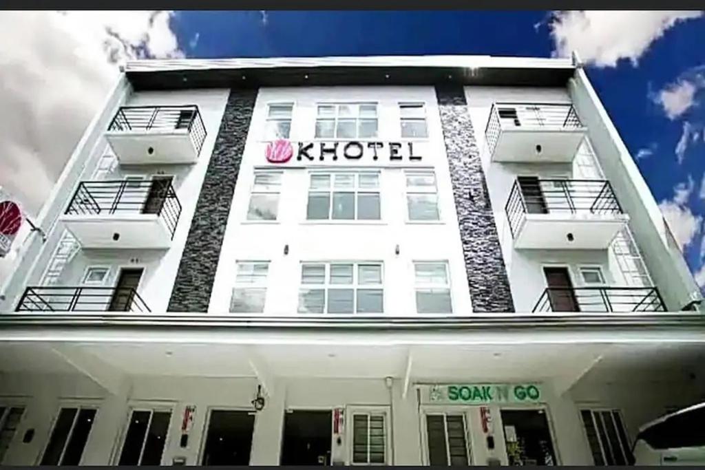 马尼拉Khotel Pasay的白色的建筑,上面有k酒店标志