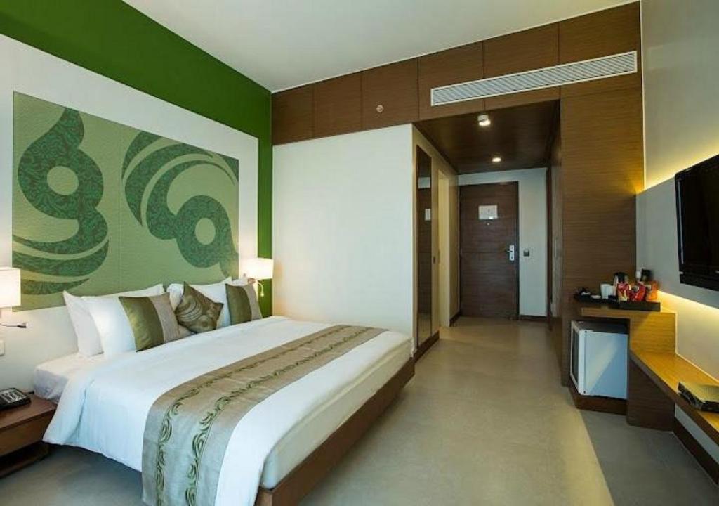 新德里Hotel Atlantis suites Near Delhi Airport的一间卧室配有一张大床和一台平面电视