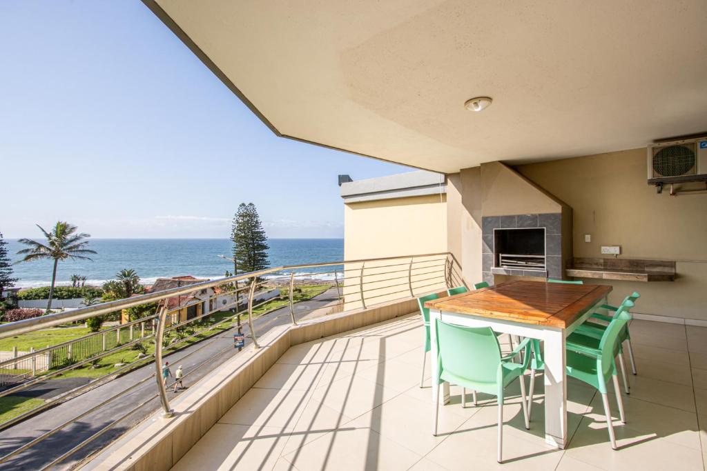 乌旺戈海滩Saints View Resort Unit 19的一个带桌椅的海景阳台