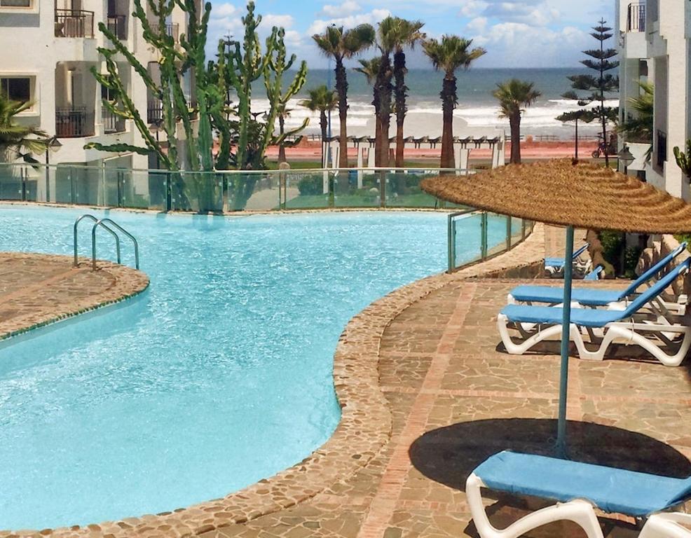 达布阿扎One bedroom apartement at Tamaris 250 m away from the beach with sea view shared pool and enclosed garden的一个带两把椅子和遮阳伞的游泳池