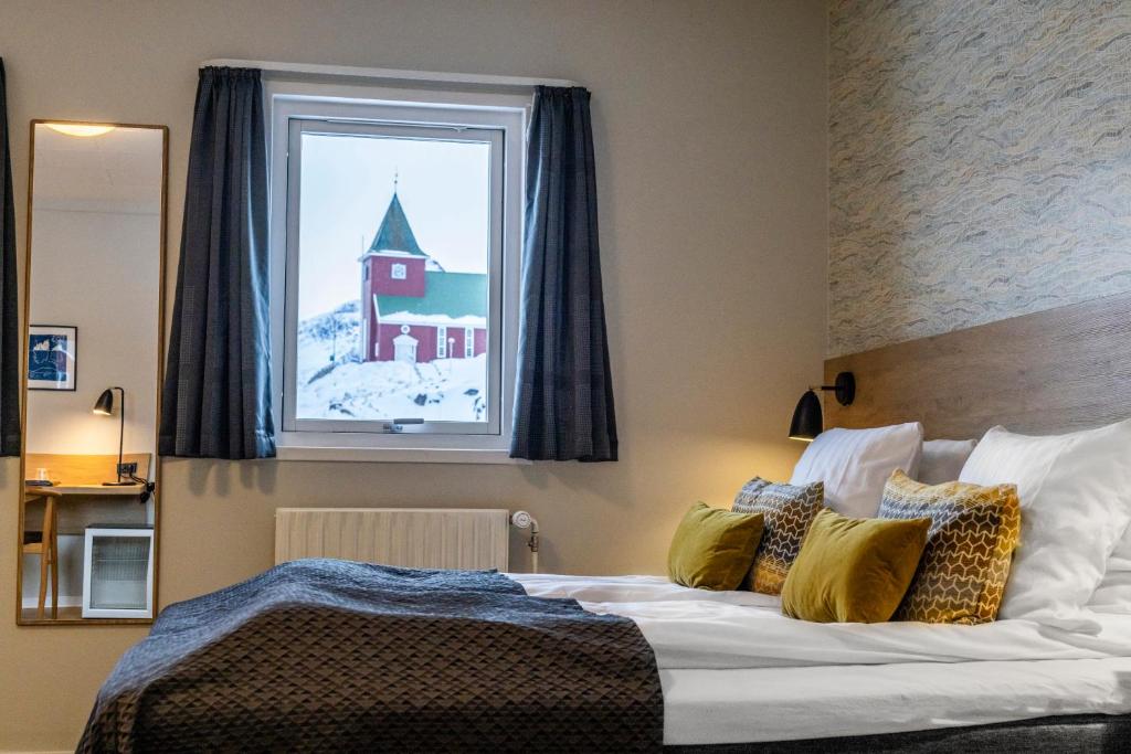 西西缪特HOTEL SØMA Sisimiut的一间卧室设有一张大床和一个窗户。