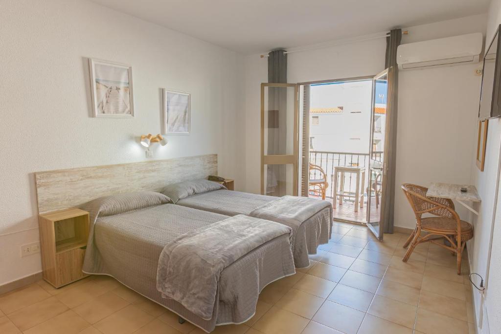 科尼尔-德拉弗龙特拉Hotel Tres Jotas Conil的一间卧室设有一张床和一个阳台