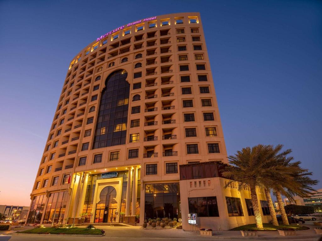 麦纳麦Mercure Grand Hotel Seef - All Suites的一座高大的建筑,上面有标志