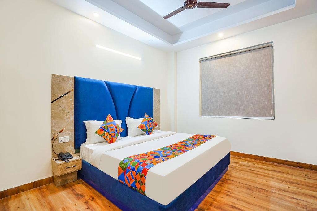 新德里FabHotel The Luxe Inn的一间卧室配有一张大床和蓝色床头板