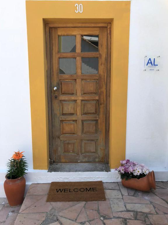 阿尔马达Margarida Guest House - Rooms的大楼前有欢迎标志的门