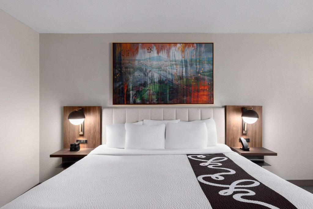 诺克斯维尔诺克斯维尔中心造纸厂拉昆塔套房酒店的一间卧室配有一张带2个床头柜的大床
