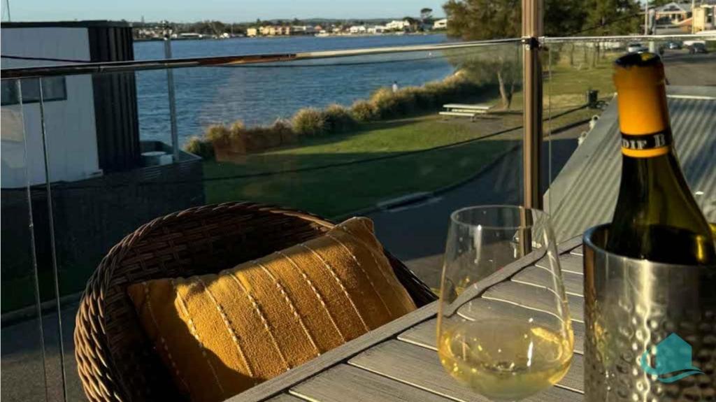 Marks PointVillage Bay Lakehouse - Spa, Pool table and Lake的一张桌子上坐着一瓶葡萄酒和一杯