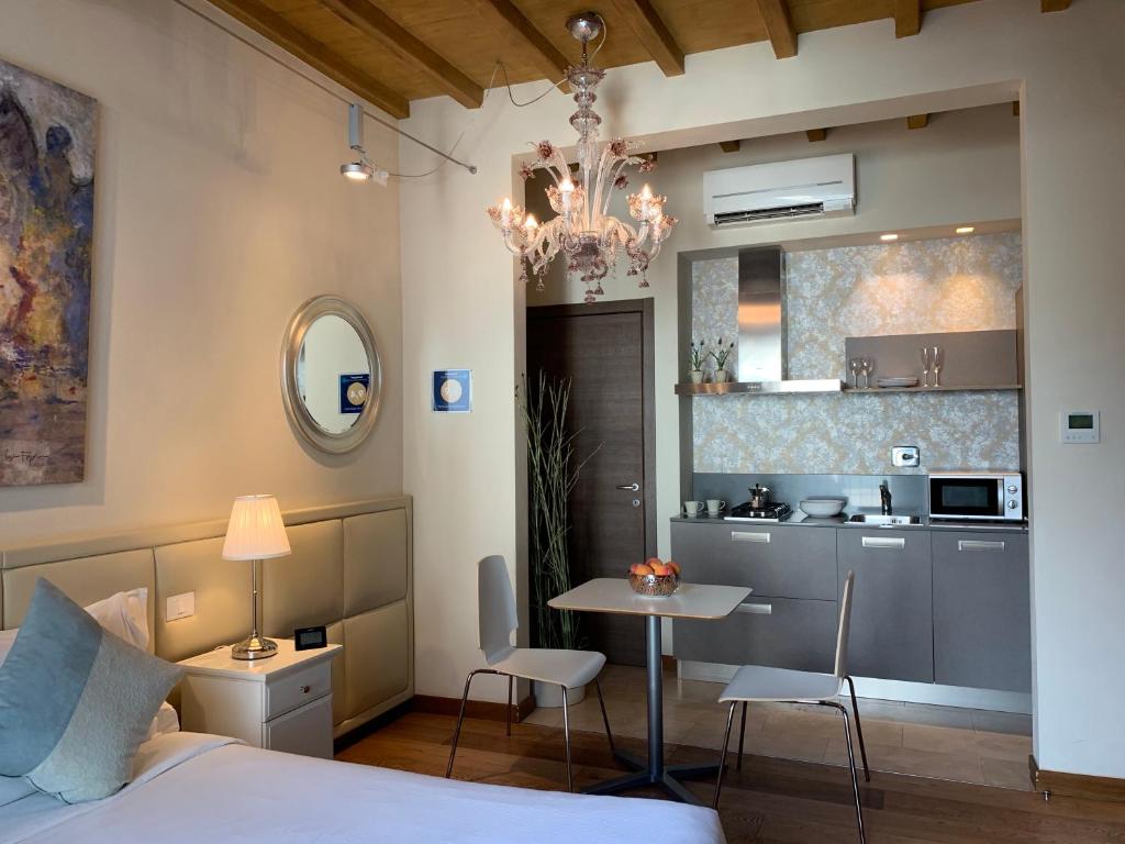 佛罗伦萨佛罗伦萨艺术公寓的一间卧室配有一张床铺和一张桌子,还设有一间厨房