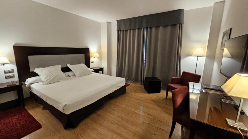 巴达霍斯博维达斯酒店的一间卧室配有一张床、一张桌子和一把椅子