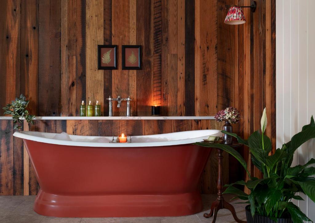 特拉利阿什酒店的木墙客房内的浴缸