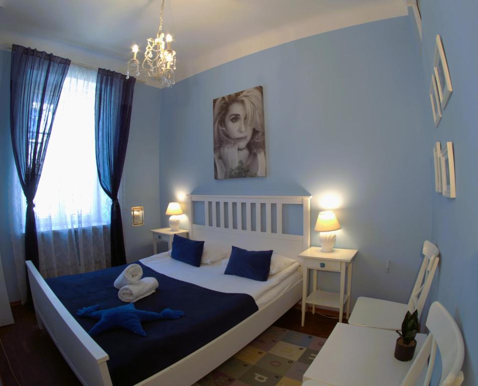 华沙Chmielna Guest House的一间卧室配有一张大床,配有蓝色的床单和蓝色的枕头。