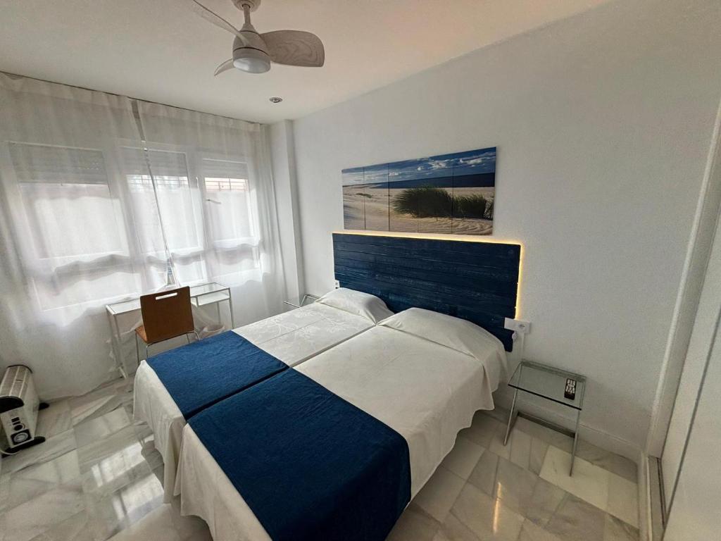 加的斯艺玛图瑞斯提科公寓酒店的卧室配有一张床,墙上挂有绘画作品