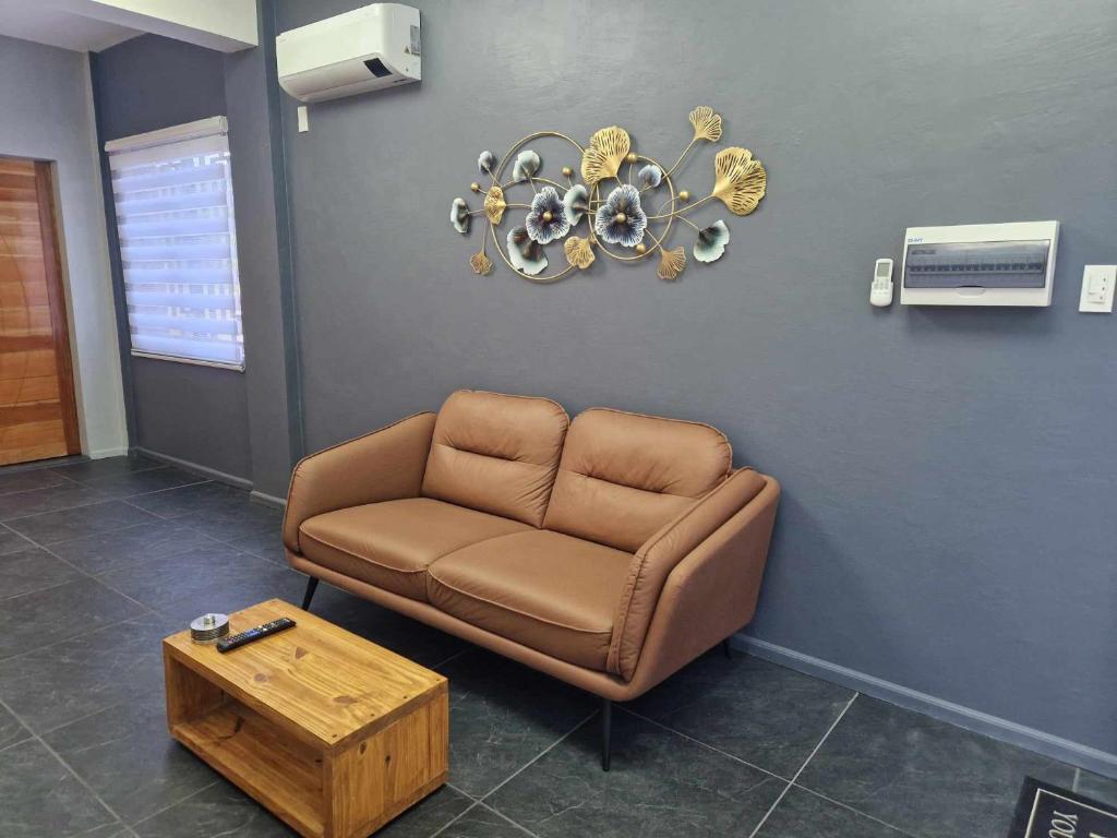 独鲁万S & R Homes的一间设有棕色沙发和桌子的等候室