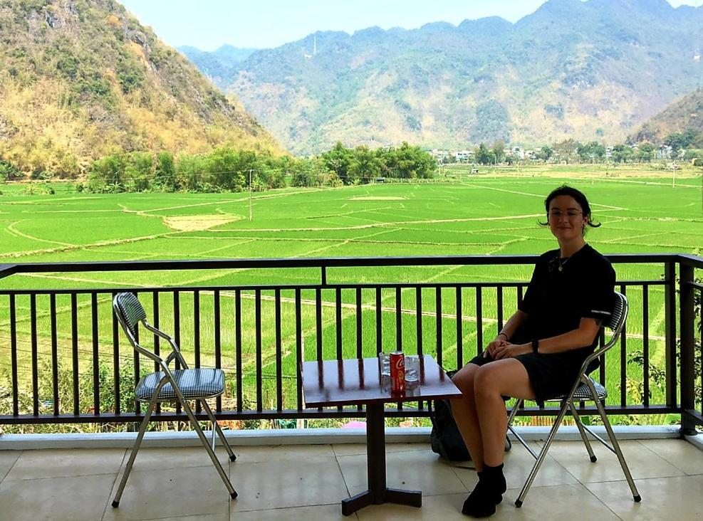 枚州县Mai chau Horizon Homestay的坐在山景阳台椅子上的女人