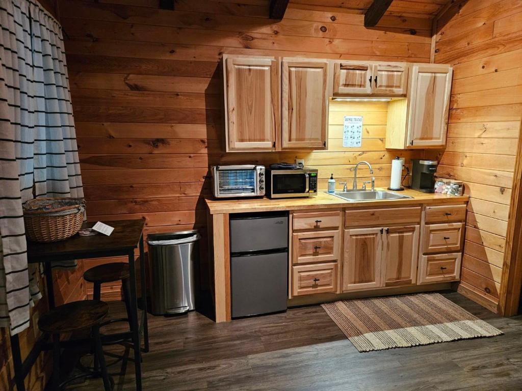 索蒂纳科奇Sylvan Valley Lodge and Cellars的厨房配有木制橱柜、水槽和炉灶。
