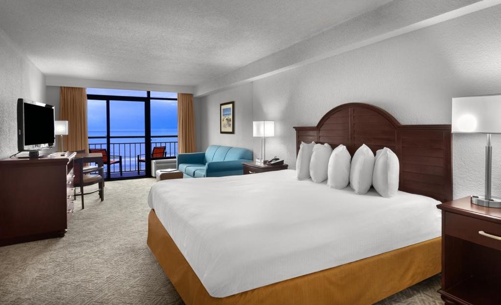 默特尔比奇贝斯特韦斯特海滩度假酒店的酒店客房设有一张大床和一个阳台。