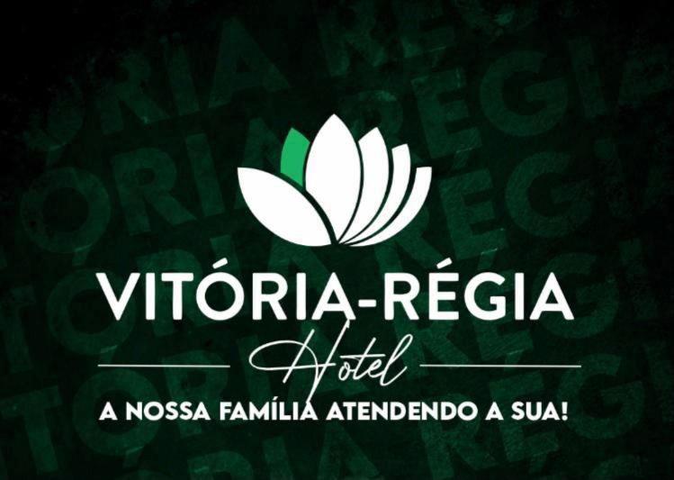 BrasiléiaHOTEL Vitoria Regia的绿色背景上的白色标志,带有标志