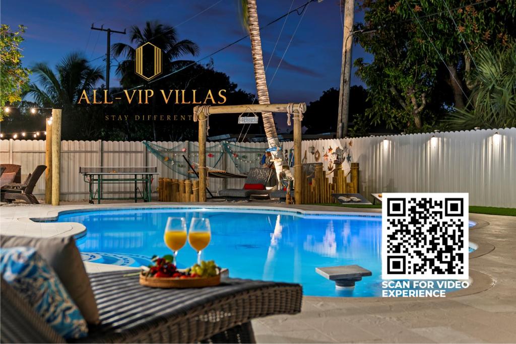 西棕榈滩Paradise Villa的游泳池,提供两杯葡萄酒