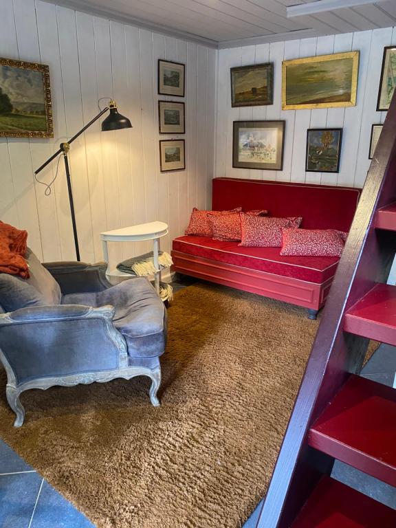 斯帕La Maisonnette des Hêtres Rouges的客厅配有两张红色的沙发和地毯。