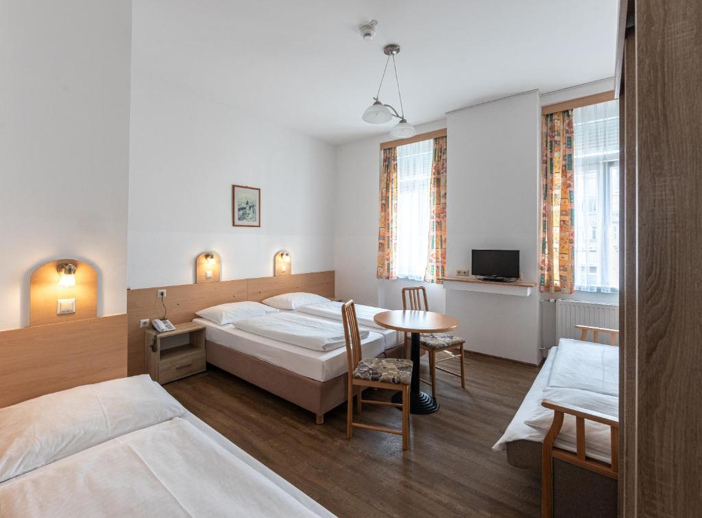 维也纳总站酒店的酒店客房设有两张床和一张桌子。