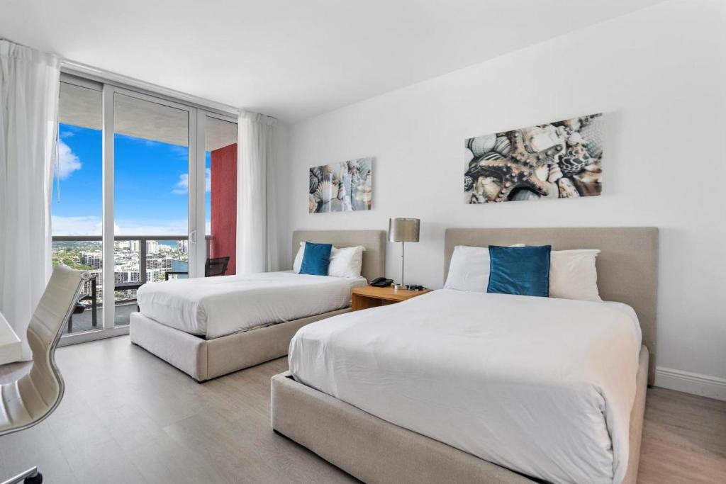 好莱坞Panoramic views Studio on the 27th floor Beachwalk的酒店客房设有两张床和窗户。