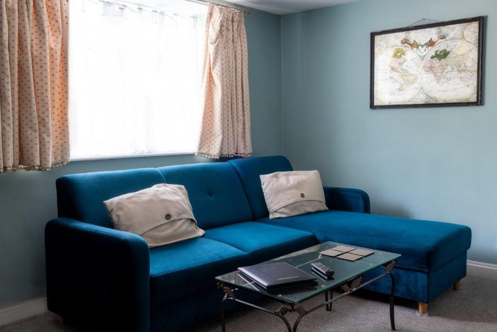 博克斯The Lodge Quaint Georgian Apartment, Wifi and Parking, near Bath的客厅配有一张蓝色的沙发,配有一张桌子