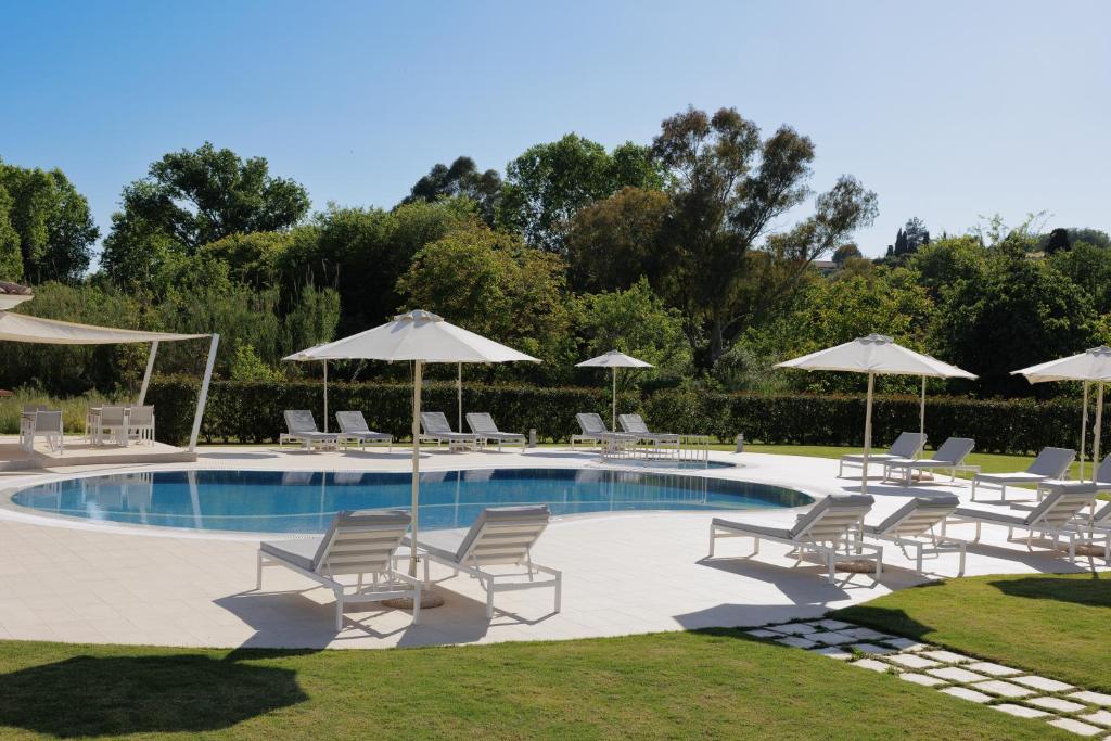 达西亚Santos Luxury Apartments的一个带躺椅和遮阳伞的游泳池
