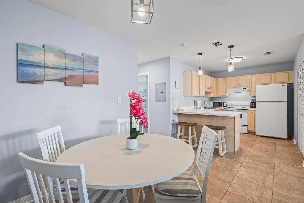格尔夫海岸Condo in Gulf Shores King Suite的厨房和餐厅配有白色桌子和椅子