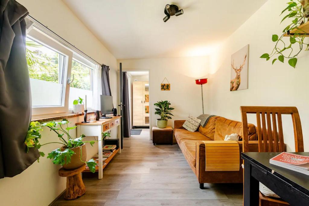 奈梅亨Tiny house - fietsverhuur, eigen keuken en badkamer的客厅配有沙发和桌子