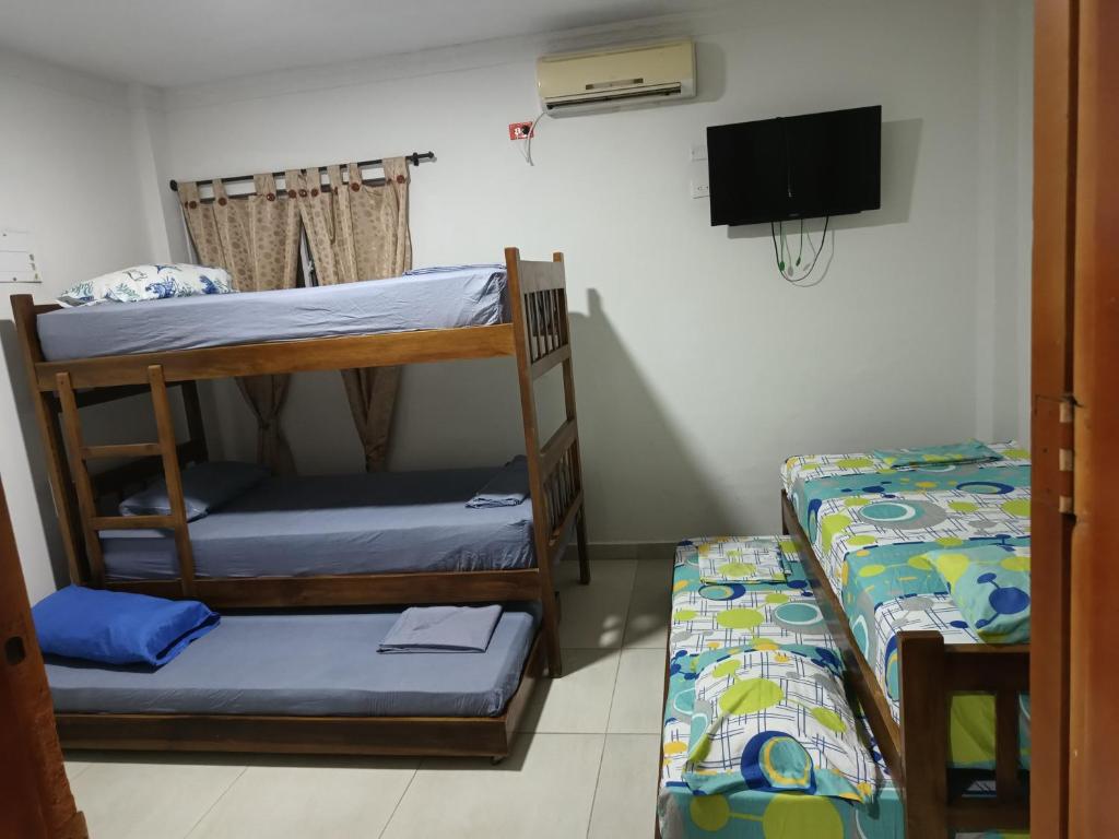 科韦尼亚斯HABITACIONES EN casa de playa的客房设有两张双层床和一台平面电视。