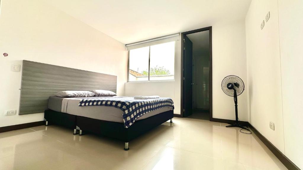 麦德林Apartamento moderno en conquistadotes, excelente ubicación.的一间卧室配有一张大床和风扇