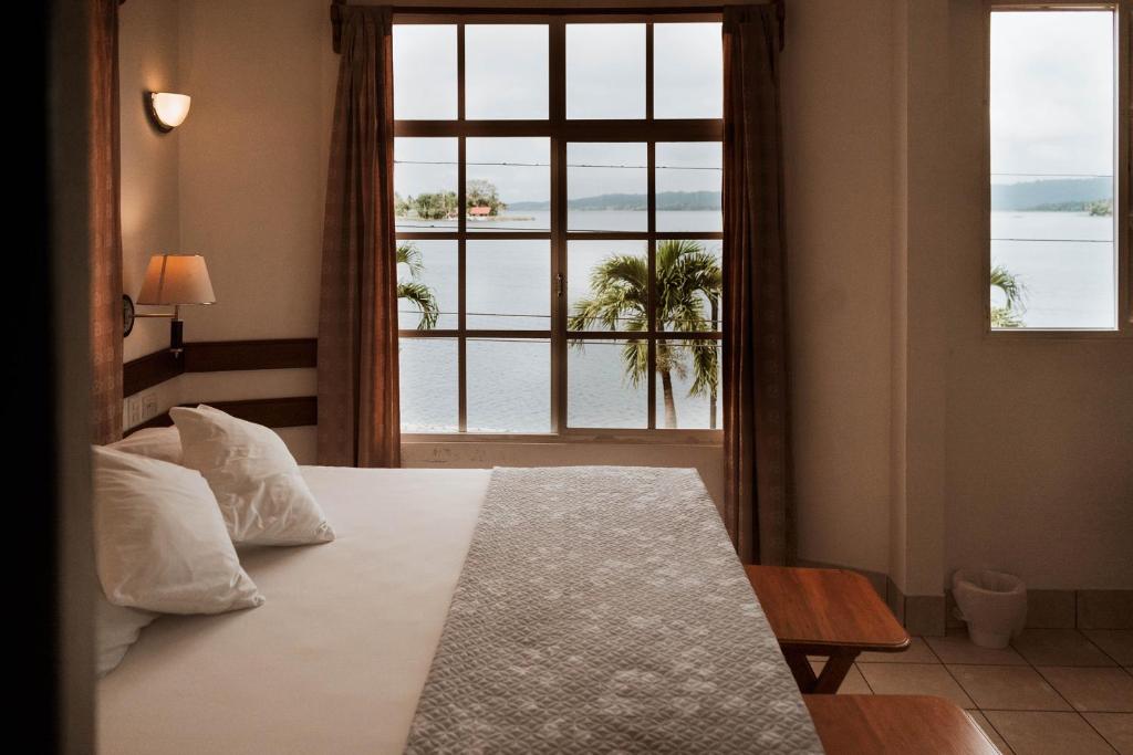 弗洛勒斯阿米莉亚卡萨酒店的一间卧室设有一张床和一个大窗户