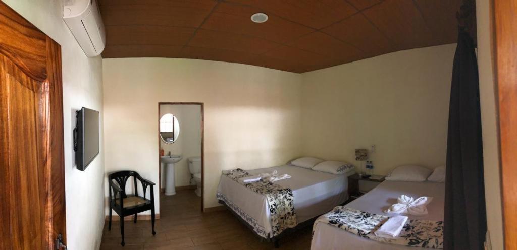 JuayúaHostal DEYLUWIN的一间卧室配有两张床、一把椅子和镜子