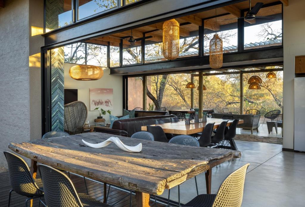 斯库库扎Rixile Kruger Lodge的一间带木桌和椅子的用餐室