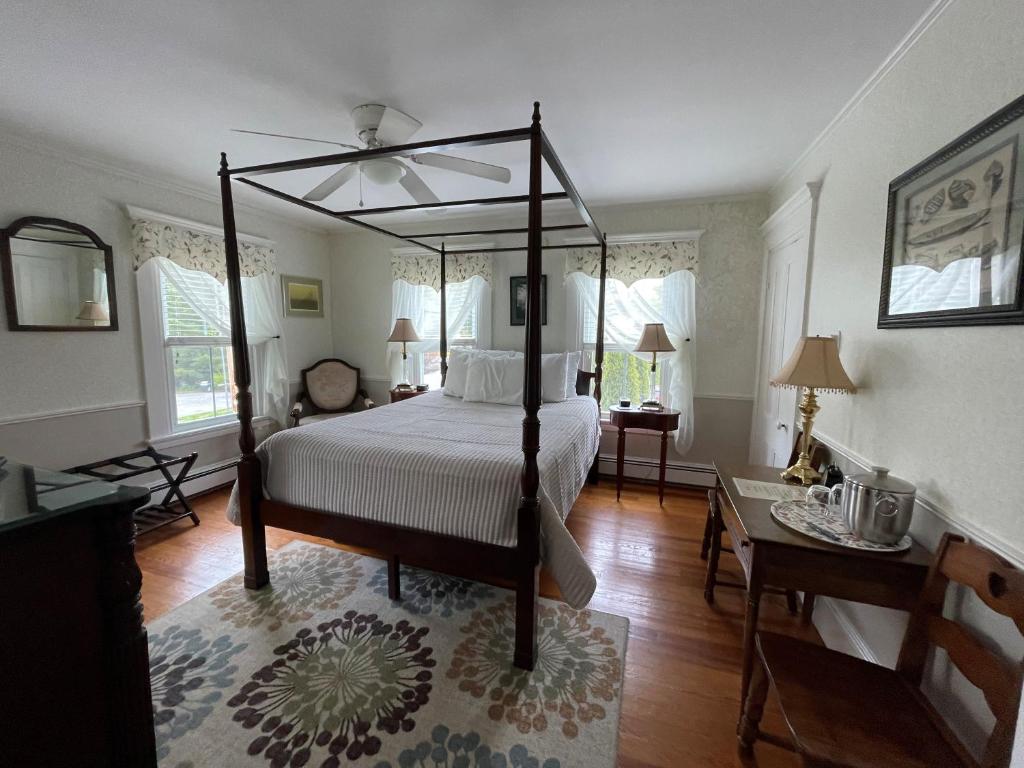奥甘奎特伯恩住宿加早餐旅馆的一间卧室配有一张天蓬床和一张桌子