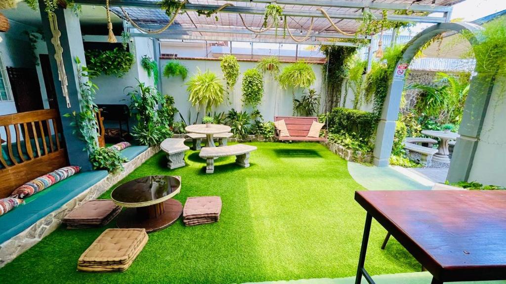 利比里亚Hostel El Pretal的一个带绿草的庭院,以及一张桌子和长凳