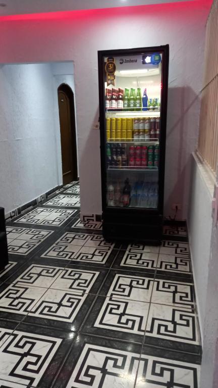 圣保罗Hotel Ferrari的冰箱装满饮料,铺在瓷砖地板