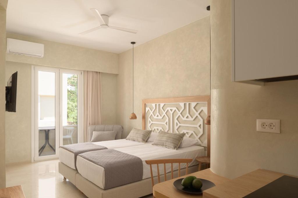 普拉基亚斯普拉基亚斯阿波罗酒店的白色卧室配有床和桌子