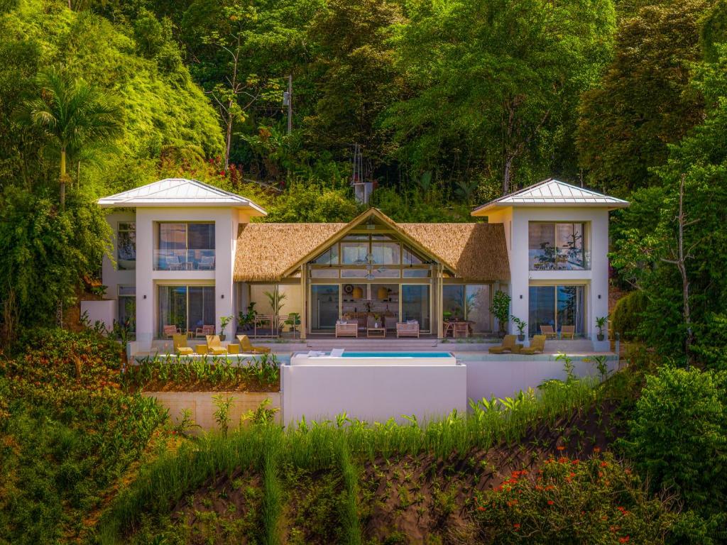 DominicalitoCasa Frenchie Luxury Oceanview Jungle Villa for 12 people的一座大房子前面设有一个游泳池