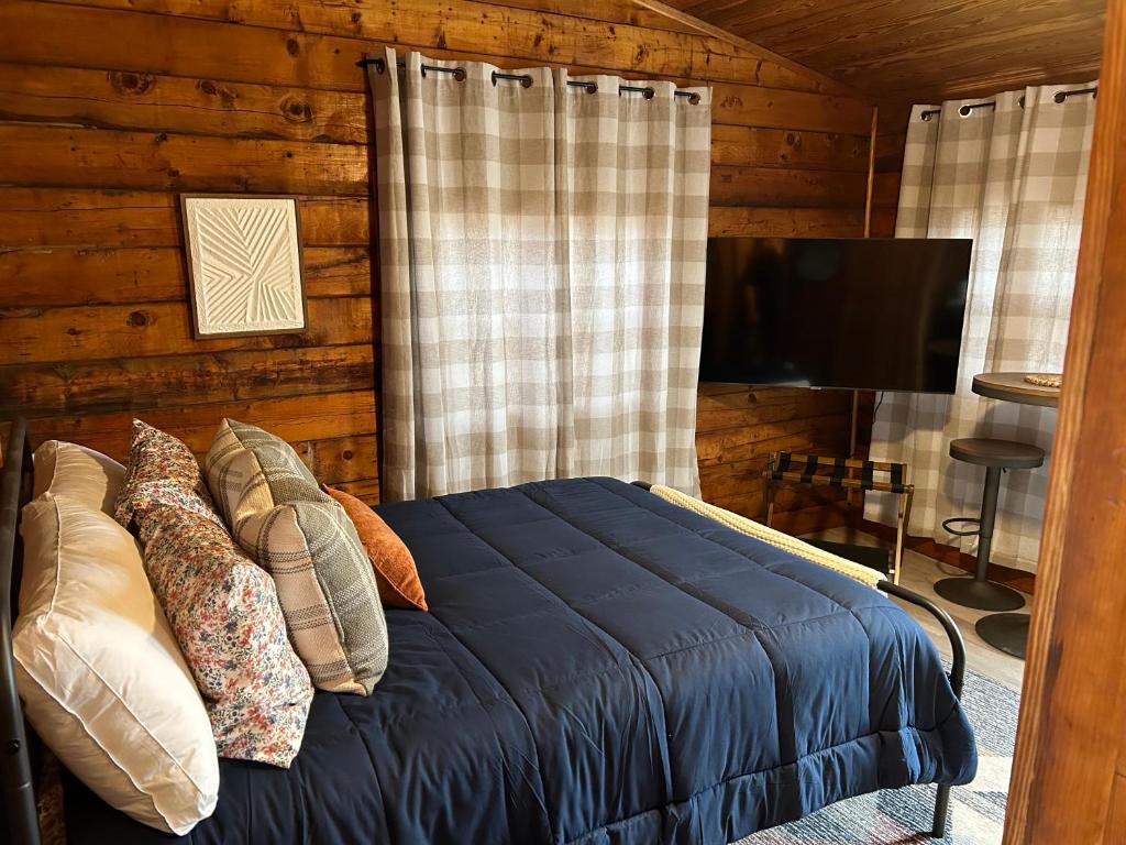 拉伯克Tack Room的一间卧室配有带枕头的床铺和电视。