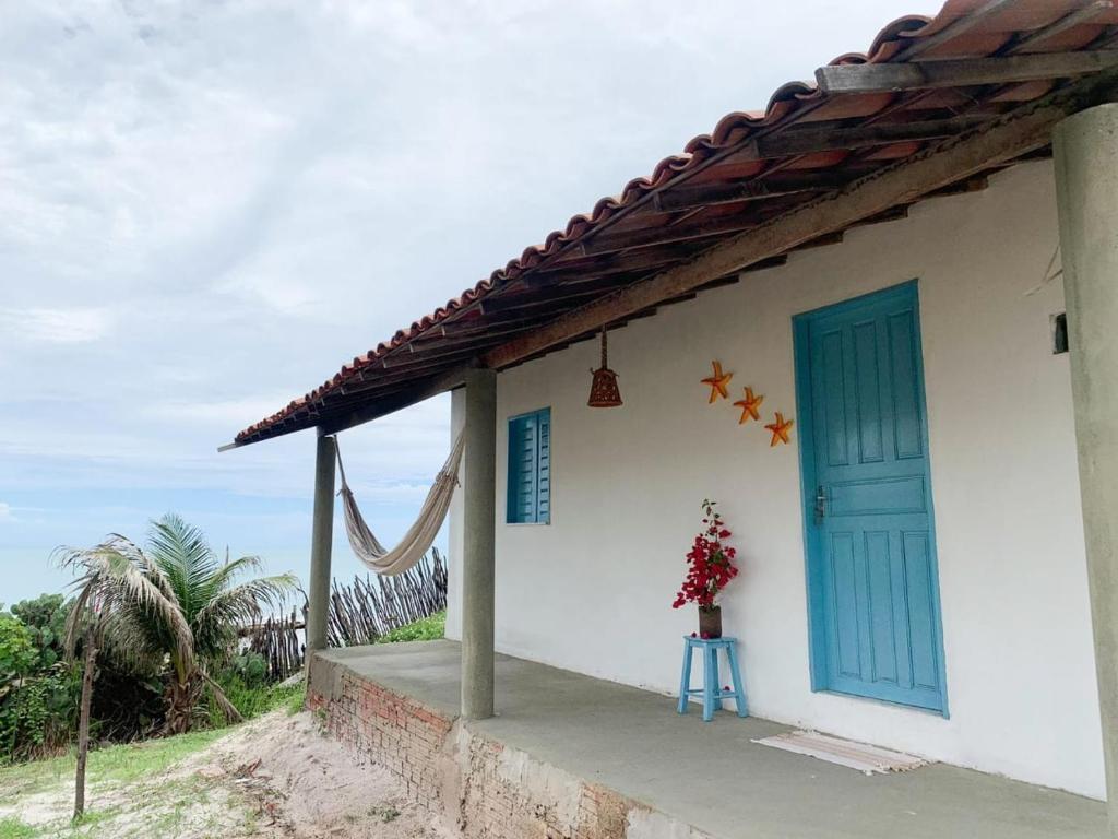 阿拉卡蒂Casinha Estrela do Mar o Oceano aos seus Pés的一座带蓝色门和花瓶的房子