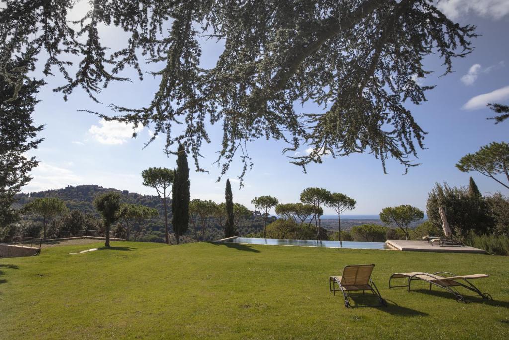 卡斯塔涅托卡尔杜奇Podere Il Castellaccio的一个带两把椅子的公园和一个游泳池