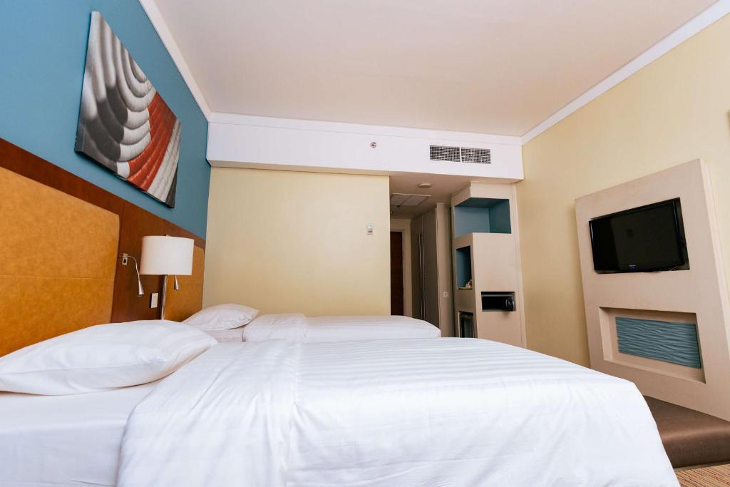 基加利Park Inn by Radisson, Kigali的卧室配有白色床和平面电视