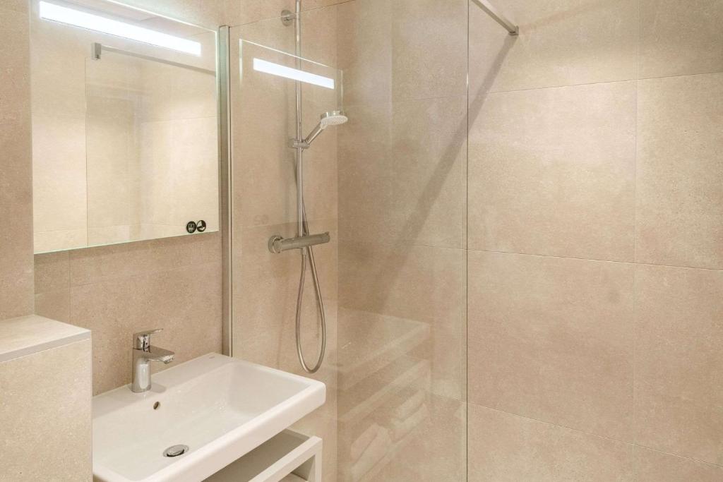 南特Brit Hotel Nantes La Beaujoire Parc Expo的带淋浴、水槽和玻璃淋浴间的浴室