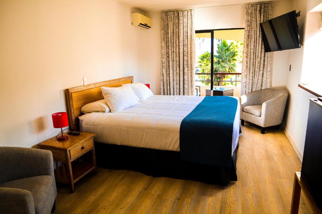拉塞雷纳Hotel Palmas de La Serena的酒店客房设有一张床和一个阳台。
