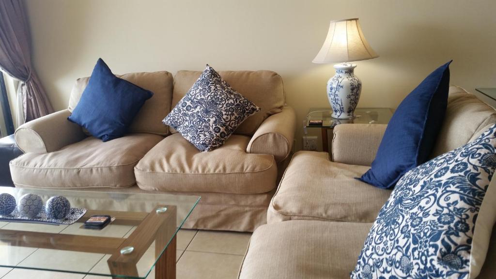 乌姆德洛蒂Bonna Vista的客厅配有沙发和蓝色枕头。